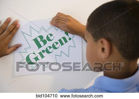 Hispanic boy putting up be green sign View Large Photo Image Stock Image - Hispanic boy putting up be green sign. Fotosearch