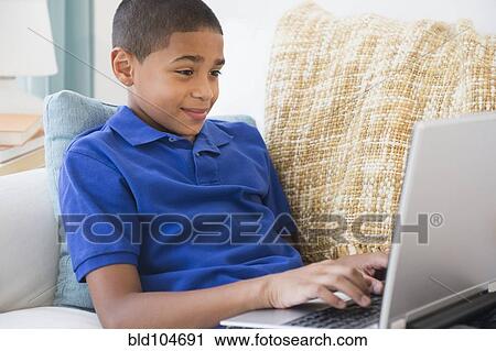 Hispanic boy typing on laptop View Large Photo Image Stock Image - Hispanic boy typing on laptop. Fotosearch