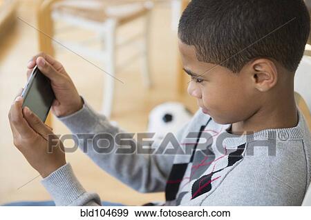 Stock Photo - Hispanic boy using cell phone. Fotosearch