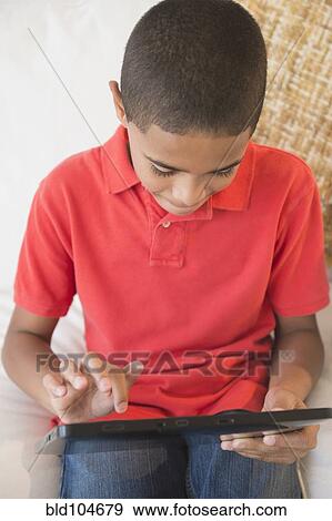Hispanic boy using digital tablet View Large Photo Image Stock Photo - Hispanic boy using digital tablet. Fotosearch