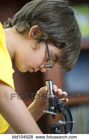 Stock Photo - Hispanic boy using microscope. Fotosearch