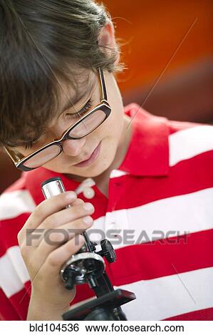 Stock Photograph - Hispanic boy using microscope. Fotosearch