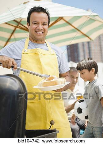 Hispanic father and son at barbecue View Large Photo Image Stock Image - Hispanic father and son at barbecue. Fotosearch
