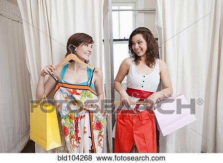 Stock Photo - Hispanic friends shopping in clothing store. Fotosearch