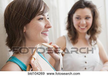 Stock Photo - Hispanic friends shopping in clothing store. Fotosearch