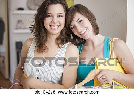 Stock Photo - Hispanic friends shopping in clothing store. Fotosearch