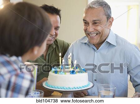 Stock Photo - Hispanic grandfather, father and son celebrating birthday. Fotosearch