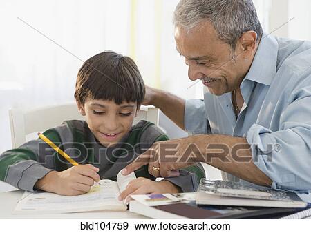 Stock Photo - Hispanic grandfather helping grandson with homework. Fotosearch