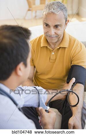 Hispanic man having his blood pressure taken View Large Photo Image Stock Photo - Hispanic man having his blood pressure taken. Fotosearch