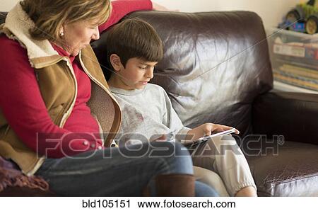 Stock Image - Hispanic mother and son using digital tablet. Fotosearch
