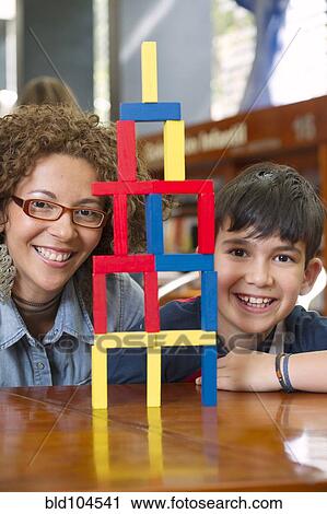 Stock Image - Hispanic teacher and student playing with blocks. Fotosearch