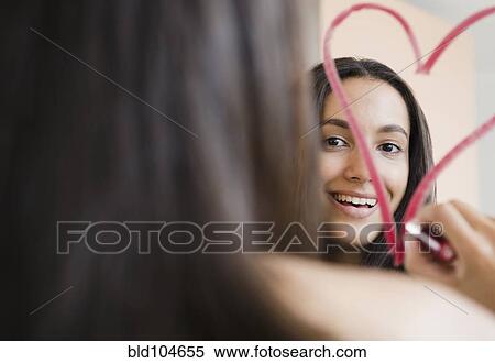 Stock Photography - Hispanic teenager drawing heart with lipstick. Fotosearch