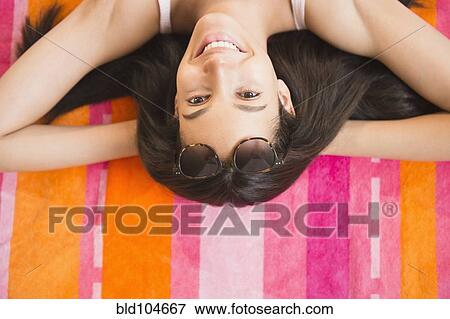 Stock Photo - Hispanic teenager laying on towel. Fotosearch