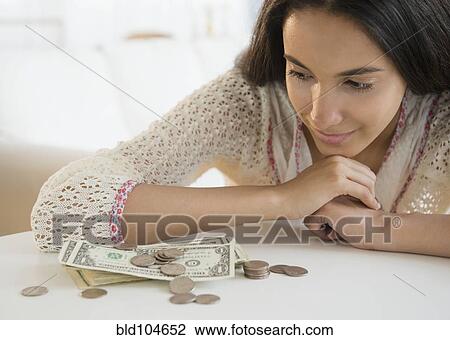 Stock Image - Hispanic teenager looking at money. Fotosearch