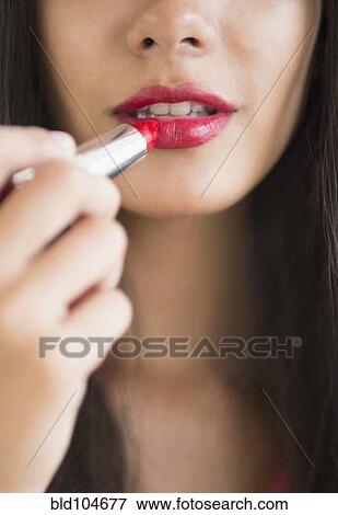 Hispanic teenager putting on lipstick View Large Photo Image Stock Photo - Hispanic teenager putting on lipstick. Fotosearch