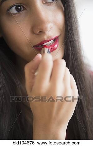 Hispanic teenager putting on lipstick View Large Photo Image Stock Photograph - Hispanic teenager putting on lipstick. Fotosearch
