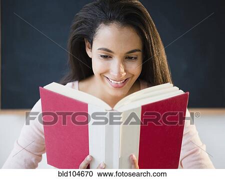 Stock Image - Hispanic teenager reading book. Fotosearch