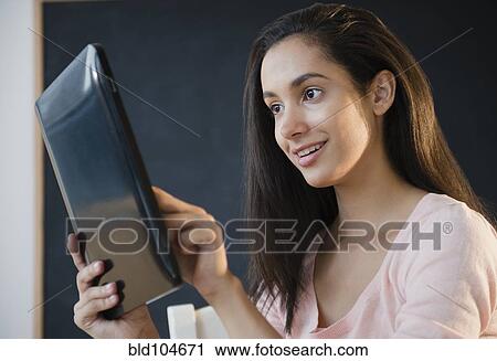 Stock Image - Hispanic teenager using digital tablet. Fotosearch