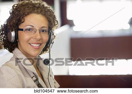 Hispanic woman listening to headphones View Large Photo Image Stock Photo - Hispanic woman listening to headphones. Fotosearch