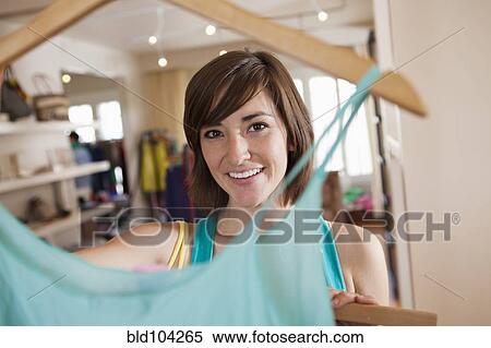 Stock Photography - Hispanic woman shopping in clothing store. Fotosearch