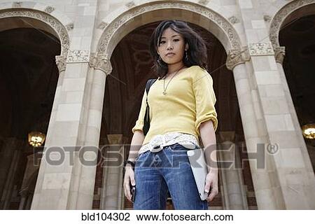 Stock Image - Korean student holding digital tablet outdoors. Fotosearch