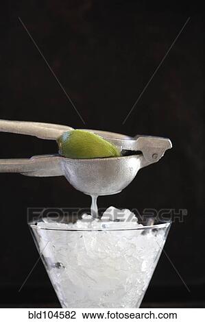 Lime being squeezed over ice View Large Photo Image Stock Image - Lime being squeezed over ice. Fotosearch