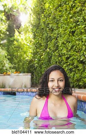 Stock Image - Mixed race girl enjoying swimming pool. Fotosearch
