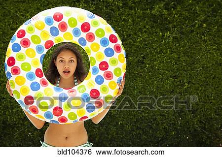 Mixed race girl holding inflatable ring View Large Photo Image Stock Photograph - Mixed race girl holding inflatable ring. Fotosearch
