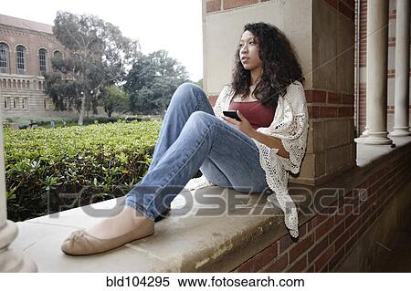 Mixed race student sitting on campus View Large Photo Image Stock Photography - Mixed race student sitting on campus. Fotosearch