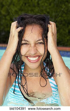 Stock Image - Mixed race teenager enjoying swimming pool. Fotosearch