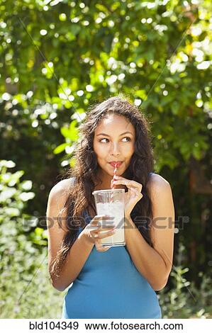 Mixed race woman drinking lemonade outdoors View Large Photo Image Stock Photo - Mixed race woman drinking lemonade outdoors. Fotosearch