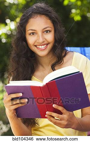 Mixed race woman reading book outdoors View Large Photo Image Stock Photograph - Mixed race woman reading book outdoors. Fotosearch