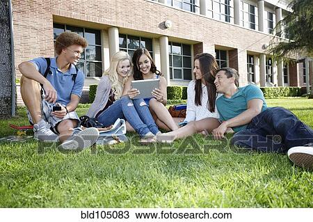 School friends hanging out on grass with digital tablet View Large Photo Image Stock Image - School friends hanging out on grass with digital tablet. Fotosearch