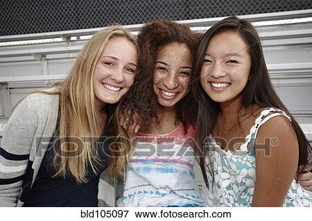 Stock Photo - School friends sitting together on bleachers. Fotosearch