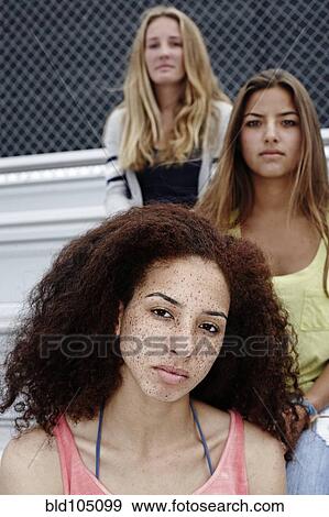 Stock Photo - School friends sitting together on bleachers. Fotosearch