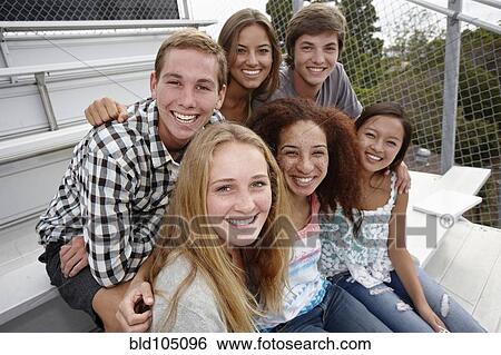 Stock Photograph - School friends sitting together on bleachers. Fotosearch