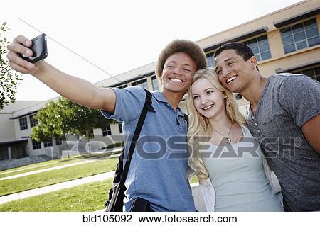 Stock Image - School friends taking self-portrait. Fotosearch