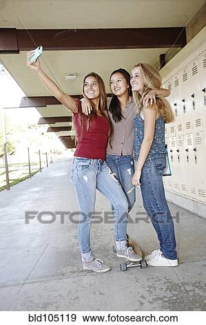 Stock Photo - School friends taking self-portrait with cell phone. Fotosearch