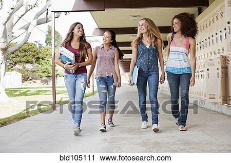 Stock Image - School friends walking in portico. Fotosearch