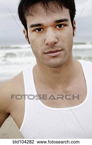 Stock Image - Serious young man on beach. Fotosearch