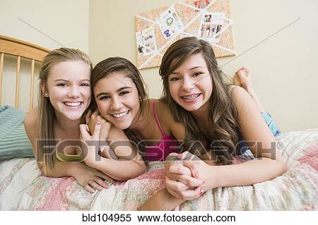 Stock Photography - Smiling Caucasian teenage girls in bedroom. Fotosearch