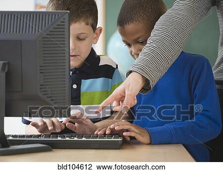 Teacher showing students how to use a computer View Large Photo Image Stock Image - Teacher showing students how to use a computer. Fotosearch