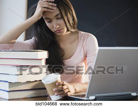 Stock Photo - Tired Hispanic teenager holding coffee cup. Fotosearch