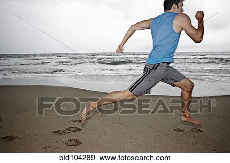 Young man running on beach View Large Photo Image Stock Photo - Young man running on beach. Fotosearch