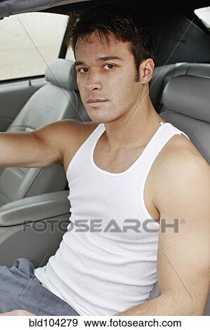 Stock Photo - Young man sitting in sports car. Fotosearch