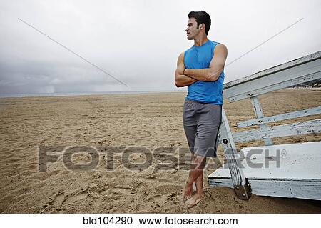 Young man standing on beach View Large Photo Image Stock Image - Young man standing on beach. Fotosearch