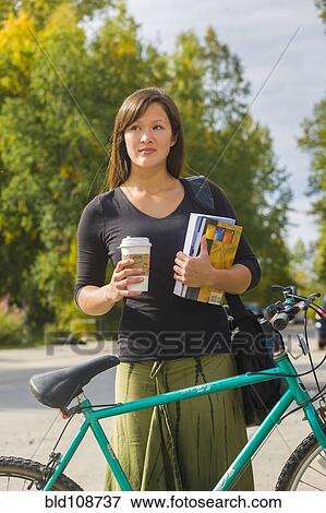 Alaskan woman carrying coffee and school books View Large Photo Image Stock Photo - Alaskan woman carrying coffee and school books. Fotosearch