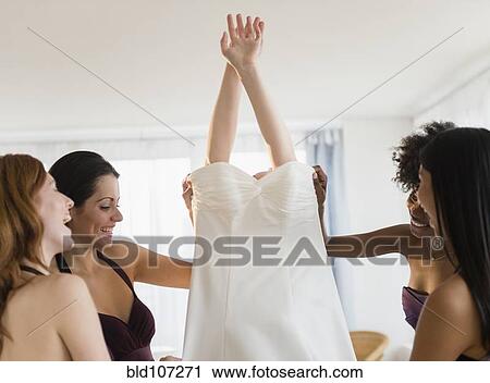 Bridesmaids helping bride into wedding dress View Large Photo Image Stock Image - Bridesmaids helping bride into wedding dress. Fotosearch