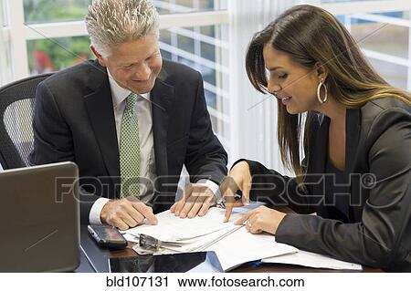 Stock Image - Business people working together in office. Fotosearch