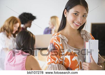 Stock Photo - Businesswoman carrying papers in office. Fotosearch
